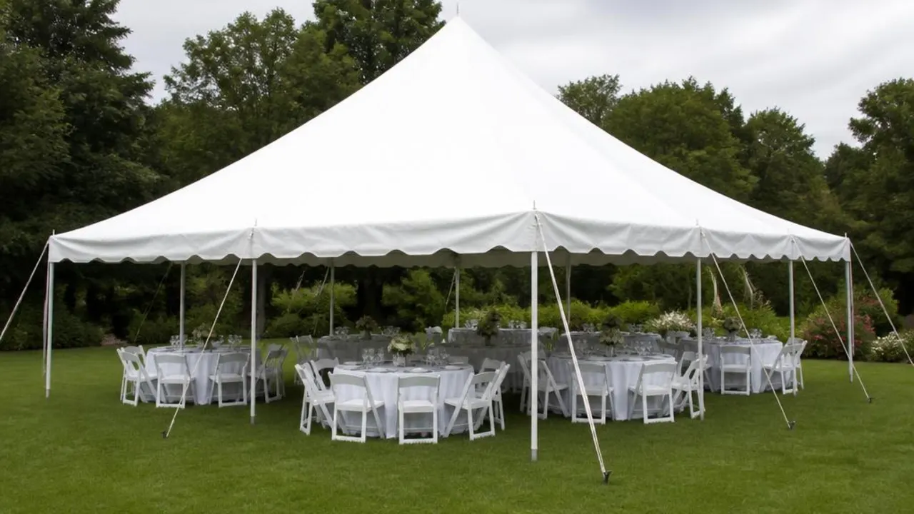 20x20 event tent with round tables and chairs set up on a Denver lawn